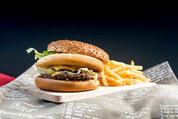 Nahaufnahme von Burger und Pommes Frites auf schwarzem Hintergrund
