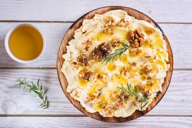 Nahaufnahme von Butterbrett mit Honig und Nüssen süßes Dessert auf der Tischplatte