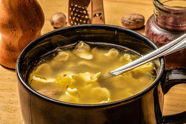 Nahaufnahme von Capeletti-Suppe, die in einer Schüssel auf dem Tisch serviert wird