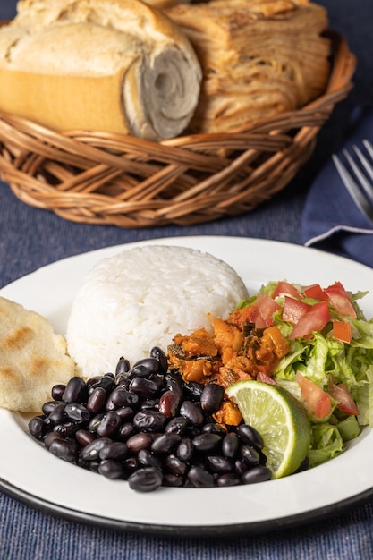 Nahaufnahme von Casado typisch costaricanisches Gericht mit Reis und Bohnen auf blauem Tischtuch