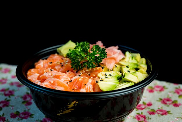 Foto nahaufnahme von chirashi in einem behälter auf einem tisch vor schwarzem hintergrund