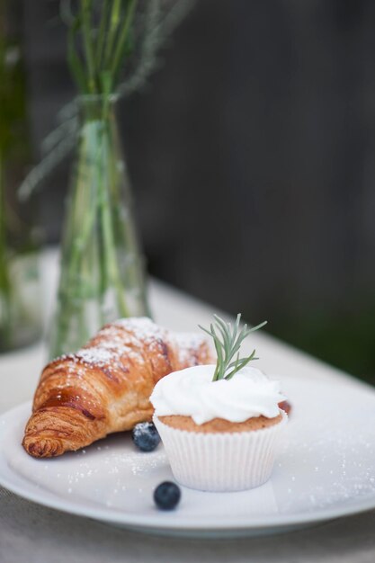 Foto nahaufnahme von cupcake mit croissant auf dem teller