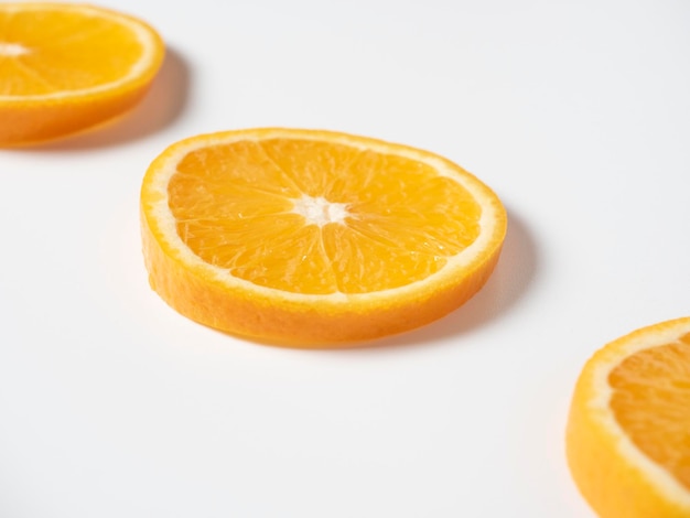 Nahaufnahme von drei Scheiben reifer Orange auf weißem Hintergrund Köstliche schöne Frucht voller Vitamine Studioaufnahme Seitenansicht