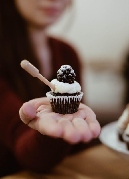 Nahaufnahme von einem Cupcake in der Hand