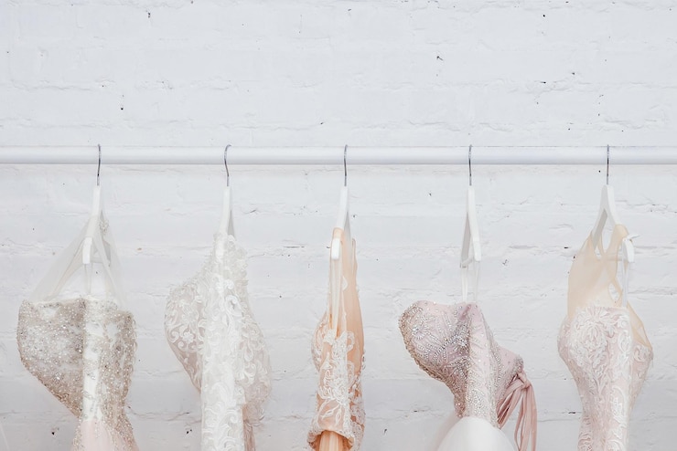 Foto nahaufnahme von einem hochzeitskleid, das an einem mantelhänger an der wand hängt