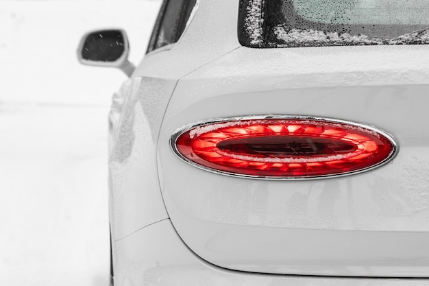 Nahaufnahme von einem LED-Rot-Hinterlicht moderner weißer Crossover-Auto mit Schnee Außendetails Automobil
