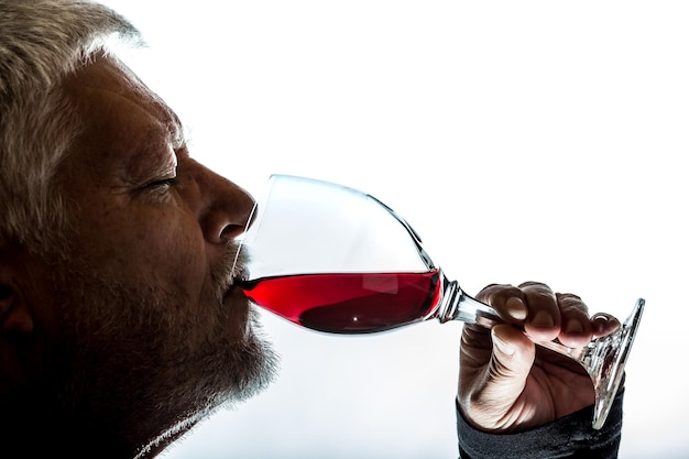 Foto nahaufnahme von einem mann, der rotwein vor weißem hintergrund trinkt