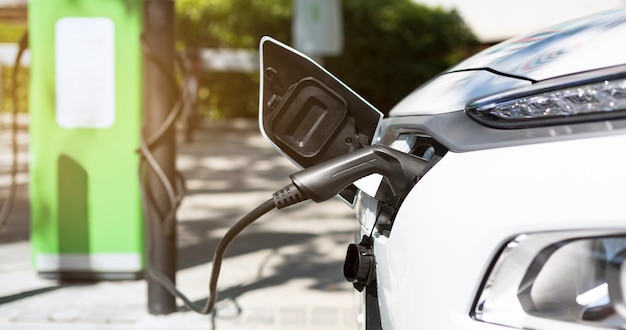 Nahaufnahme von Elektroautos, die Batterie aufladen. Ökologisches Ladegerät für Hybridfahrzeuge. Konzept der nachhaltigen Energie und des Transports. Saubere Ökologie.