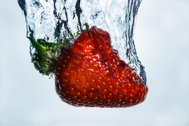 Foto nahaufnahme von erdbeeren, die ins wasser spritzen