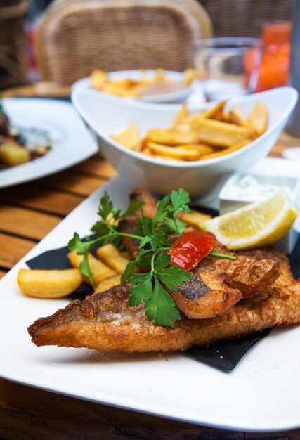 Nahaufnahme von Fisch und Pommes auf einem Teller auf dem Tisch