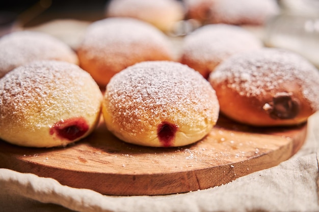 Foto nahaufnahme von flauschigen donuts gefüllt mit marmelade auf einem tablett auf dem tisch unter den lichtern