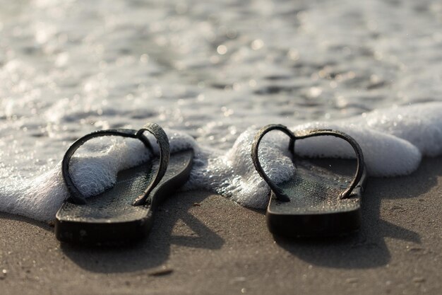 Foto nahaufnahme von flip-flops auf dem sand am strand