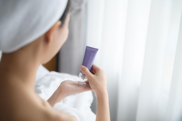 Nahaufnahme von Frauen, die Bodylotion-Creme auf die Hand auftragen