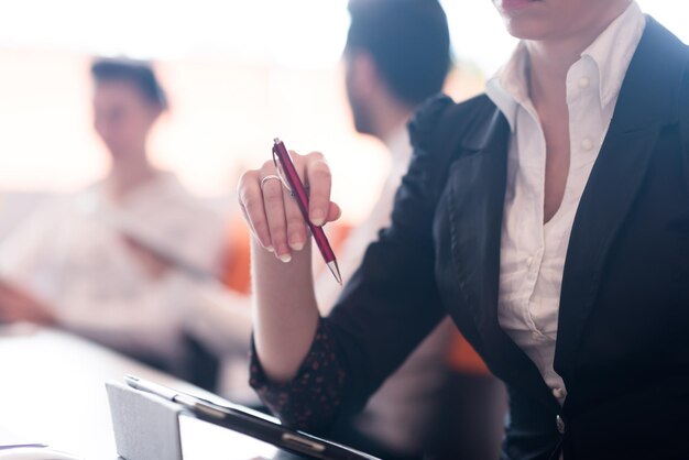 Nahaufnahme von Frauenhänden, die einen Stift bei einem Geschäftstreffen halten