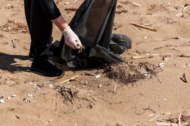 Nahaufnahme von Freiwilligen, die Müll am Strand sammeln