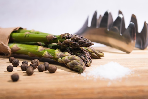 Nahaufnahme von frischem grünem Bio-Spargel mit Salz und Pfeffer Konzept für gesundes vegetarisches Essen