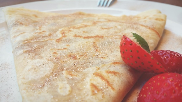Nahaufnahme von frischen Pfannkuchen und Erdbeeren, die auf einem Teller serviert werden
