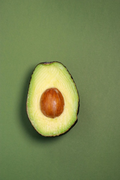 Nahaufnahme von frischer reifer Avocado auf grünem Hintergrund, Kopierraum