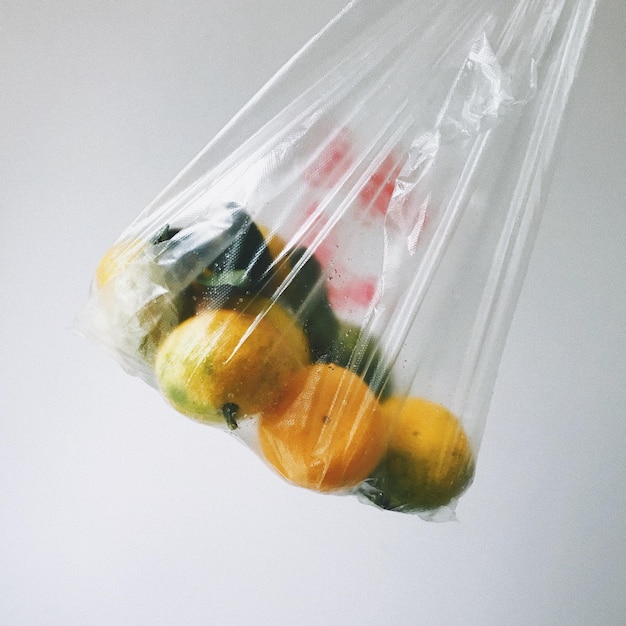 Nahaufnahme von Früchten in Plastiktüten auf weißem Hintergrund