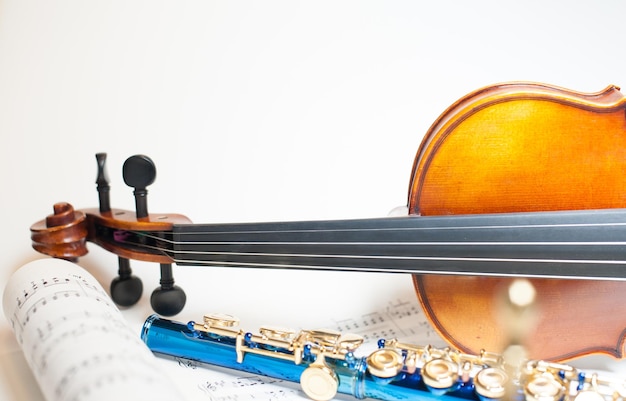 Foto nahaufnahme von geige und flöte mit musikblatt auf weißem hintergrund