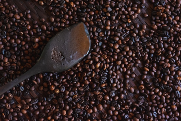 Nahaufnahme von gerösteten Kaffeebohnen und Holz Paddel