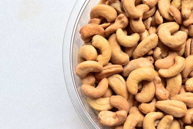 Nahaufnahme von gesalzenen Cashews in einer Schüssel auf weißem Hintergrund