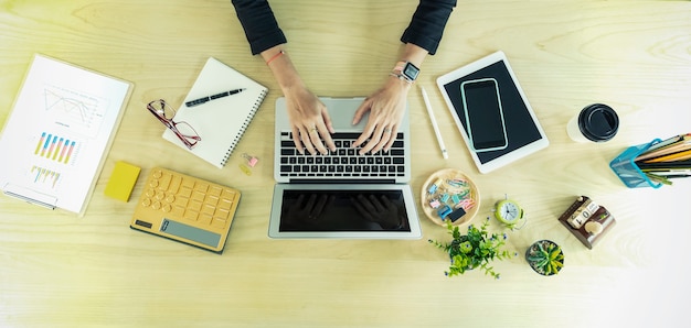 Nahaufnahme von Geschäftsleuten Händen, die mit Laptop und Zubehör auf Tabelle arbeiten