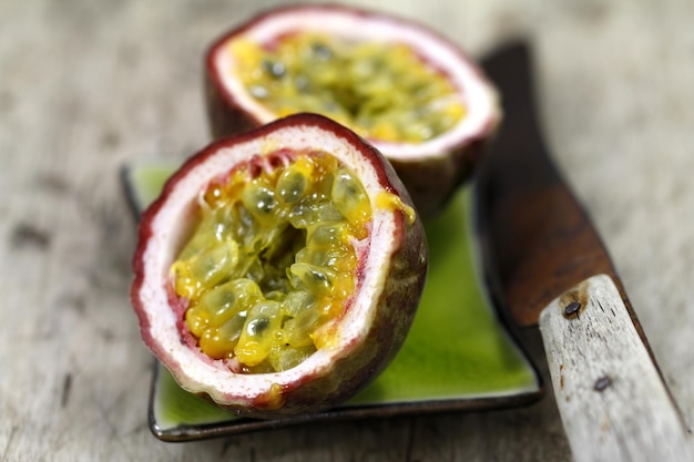 Nahaufnahme von geschnittener Passionsfrucht mit Tischmesser auf dem Tisch