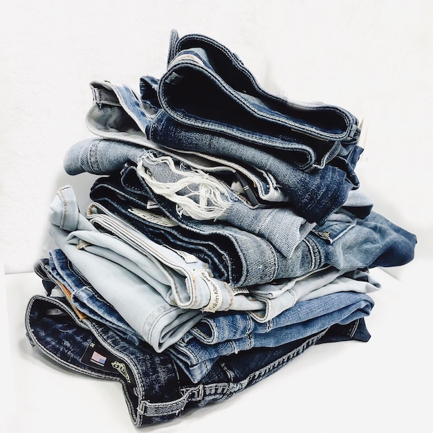 Nahaufnahme von gestapelten Jeans auf weißem Hintergrund