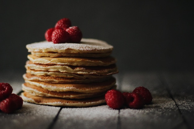 Nahaufnahme von gestapelten Pfannkuchen mit Himbeeren auf dem Tisch