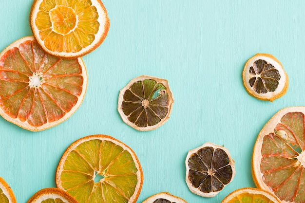 Nahaufnahme von getrockneten Zitruschips Orangen-Zitronen-Grapefruit auf türkisfarbenem Hintergrund