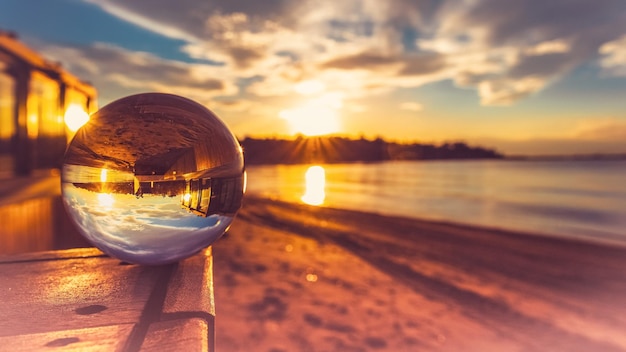 Foto nahaufnahme von glas am strand gegen den himmel bei sonnenuntergang