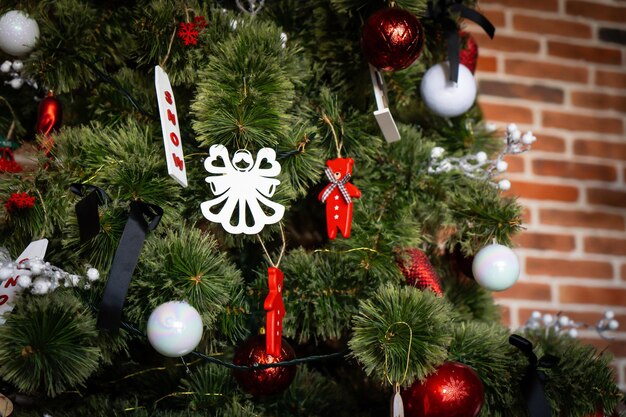 Nahaufnahme von goldenen und roten Kugeln am Weihnachtsbaum. Bokeh-Girlanden im Hintergrund. Konzept des neuen Jahres.