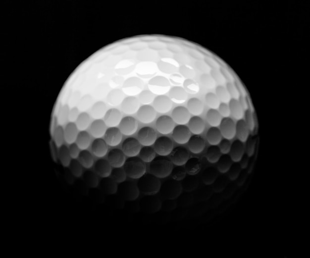 Foto nahaufnahme von golfball, isoliert auf schwarzem hintergrund