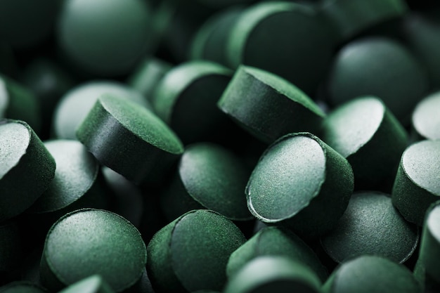 Nahaufnahme von grünen Tabletten mit Bio-Spirulina als Texturhintergrundmakro im Vollbildmodus