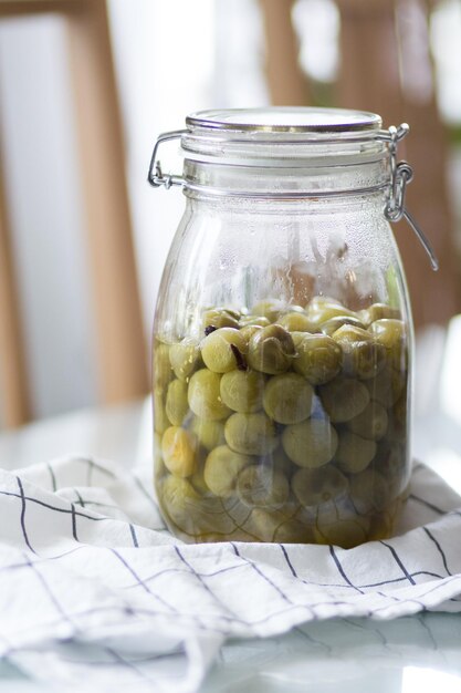 Foto nahaufnahme von grünen tomaten in einem glaskrug auf dem tisch