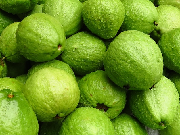 Nahaufnahme von Guaven mit Wassertropfen darauf unter den Lichtern - perfekt für Food-Konzepte