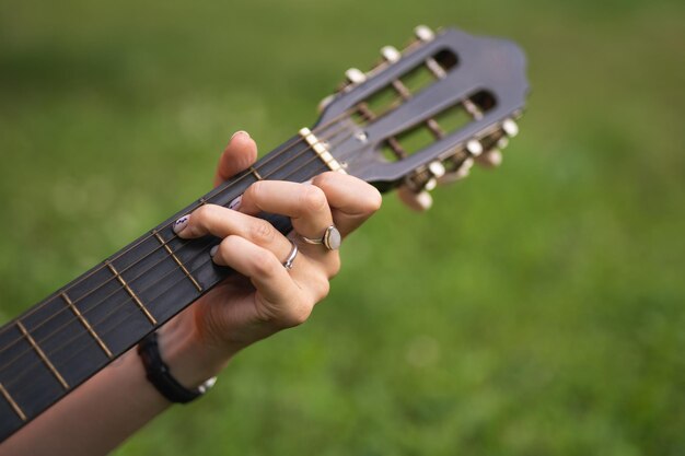 Nahaufnahme von Händen, die einen Akkord auf die Gitarre legen