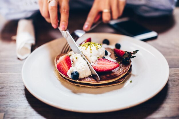 Nahaufnahme von Händen, die Pfannkuchen essen