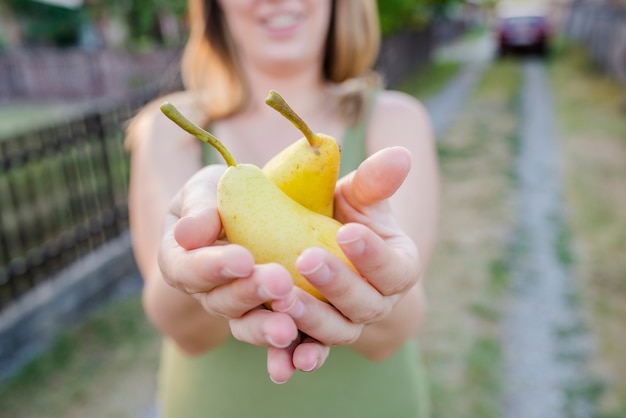 Nahaufnahme von Händen - Frau mit einer gelben Birne - Thanksgiving - Gartenarbeit