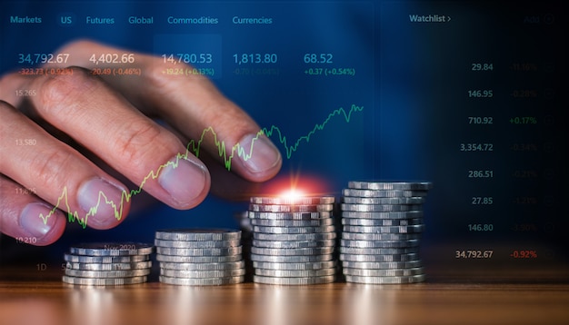 Nahaufnahme von Hand, die Münzen zählt, stapeln sich auf dem Schreibtisch in der Konzeptgeschäftsinvestitionshandelsbörse, Trading-Online-Händler mit digitalem Chart