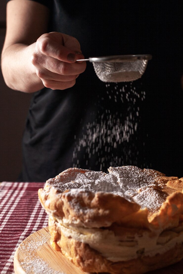 Foto nahaufnahme von handzuckerpulver auf dem kuchen