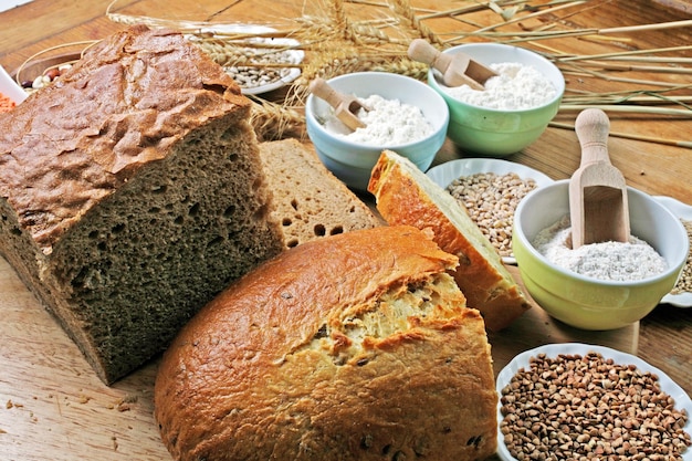 Nahaufnahme von hausgemachtem Brot und notwendigen Zutaten auf dem Tisch