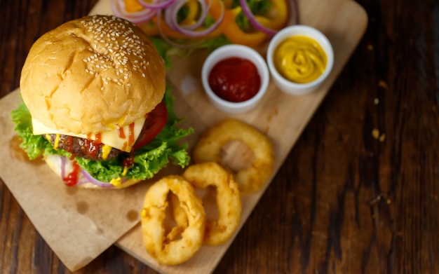 Nahaufnahme von hausgemachtem Rindfleisch-Hamburger mit frischem Gemüse mit zweifarbigem Catchup.