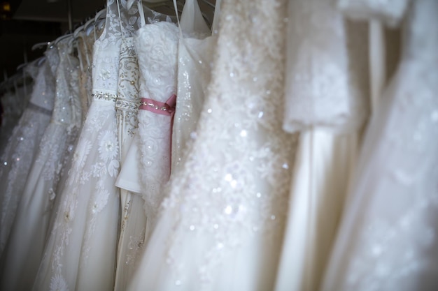 Nahaufnahme von Hochzeitskleidern in einem Brautladen