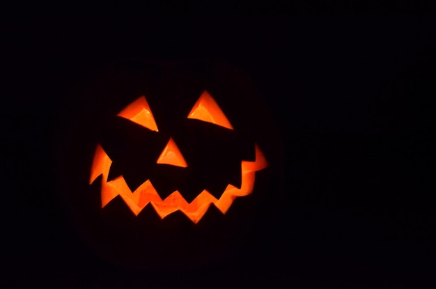 Nahaufnahme von Jack-o-Lantern vor schwarzem Hintergrund