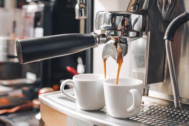 Nahaufnahme von Kaffee, das aus der Maschine in die Tasse gegossen wird