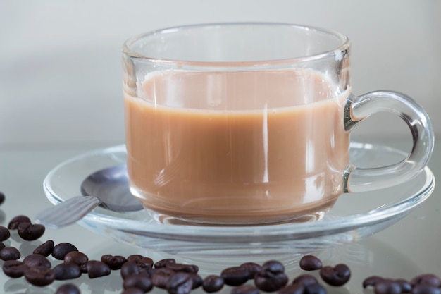 Nahaufnahme von Kaffeebohnen und Tasse auf dem Tisch