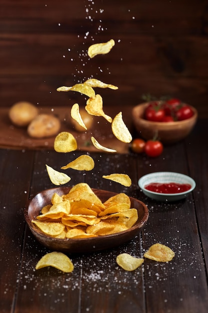 Nahaufnahme von Kartoffelchips, die auf den Tisch fallen