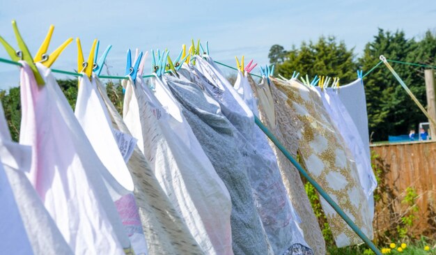 Nahaufnahme von Kleidung, die auf der Wäscheleine gegen den Himmel trocknet